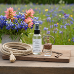 Load image into Gallery viewer, Room spray bottle and car perfume, rope, and decorative item on a wooden surface with flowers in the background. Southern Charm Farmhouse.