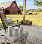 Load image into Gallery viewer, Three hand poured Candles on a glass table with a wooden chair and scenic background of a barn and field. Southern Charm Farmhouse.