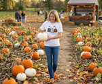 Load image into Gallery viewer, Woman holding a pumpkin in a pumpkin patch with other people and pumpkins in the background. Southern Charm Farmhouse.