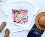 Load image into Gallery viewer, White t-shirt with pink boots and bows graphic and text, placed on a white surface with a hat and jeans. Southern Charm Farmhouse.