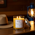 Load image into Gallery viewer, 2 wick hand poured Butterscotch and Bourbon Candle on a wooden surface next to a hat and lantern. Southern Charm Farmhouse.