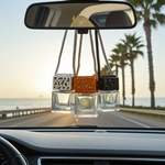 Load image into Gallery viewer, Car air freshener hanging from a rearview mirror with a scenic road and palm trees in the background. Southern Charm Farmhouse.