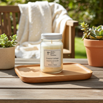 Load image into Gallery viewer, 16 oz Mason Jar of hand poured candle labeled 'Coastal Cottage' on a wooden tray with plants and a chair in the background. Southern Charm Farmhouse.
