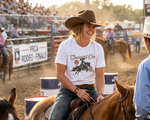 Load image into Gallery viewer, Woman on a horse wearing a 'Cowgirl On' t-shirt at a rodeo event. Southern Charm Farmhouse.