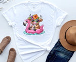 Load image into Gallery viewer, A white t-shirt with a graphic print of a cow sitting on a flamingo, accompanied by a hat and a pair of sunglasses. Southern Charm Farmhouse.