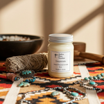 Load image into Gallery viewer, Hand poured 16 oz Mason jar Candle labeled 'Desperado' on a patterned surface with jewelry and a bowl in the background. Southern Charm Farmhouse.
