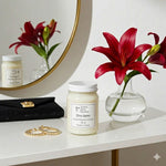 Load image into Gallery viewer, 16 oz hand poured Diva Candle on a surface next to a vase of red lilies and a mirror. Southern Charm Farmhouse.