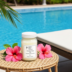 Load image into Gallery viewer, Hawaiian Tropic Candle in a 16 oz Mason jar with pink flowers on a table by a pool. Southern Charm Farmhouse.