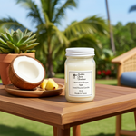 Load image into Gallery viewer, 16 oz Mason Jar of Hawaiian Tropic hand poured candle with label on a wooden table outdoors, surrounded by plants and a coconut. Southern Charm Farmhouse.