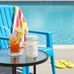 Load image into Gallery viewer, Jamaica Me Crazy hand poured 16 oz Mason Jar Candle and iced tea on a table by a poolside with a colorful towel and flip-flops. Southern Charm Farmhouse