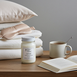 Load image into Gallery viewer, 16 oz Mason jar Lavender hand poured Candle, mug with spoon, open book, and sleep mask on a wooden surface with pillows in the background. Southern Charm Farmhouse
