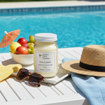 Load image into Gallery viewer, Pina Colada Candle in a 16 oz Mason Jar with fruit bowl, sunglasses, and straw hat by a poolside. Southern Charm Farmhouse.