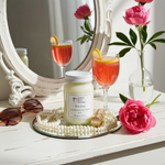 Load image into Gallery viewer, Pink Diva Candle in a 16 oz Mason Jar on a decorative tray, surrounded by pink flowers and a glass of a sparkling strawberry with a lemon in it drink. Southern Charm Farmhouse.