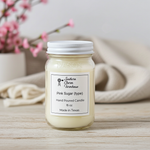 Load image into Gallery viewer, Hand poured candle labeled 'Pink Sugar' from Southern Charm Furnace on a wooden surface with pink flowers in the background. Southern Charm Farmhouse.