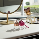 Load image into Gallery viewer, Two small car perfume bottles on a vanity table with a mirror and makeup brushes in the background. Southern Charm Farmhouse.
