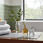 Load image into Gallery viewer, Two small glass car perfume bottles with decorative caps on a wooden surface in a bathroom setting. Southern Charm Farmhouse.