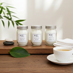 Load image into Gallery viewer, Three 4 oz hand poured jars of candles on a wooden surface with a cup of tea and leaves. Southern Charm Farmhouse.