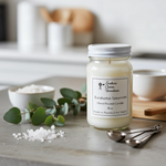 Load image into Gallery viewer, 16 oz Mason Jar Eucalyptus Spearmint candle with label on a kitchen counter with eucalyptus leaves and salt crystals. Southern Charm Farmhouse.