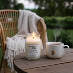 Load image into Gallery viewer, 16 oz hand poured Candle named Texas Twilight in a mason jar and a mug of tea on a wooden table outdoors. Southern Charm Farmhouse.