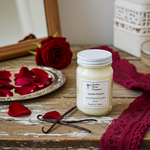 Load image into Gallery viewer, 16 oz mason Jar of vanilla passion hand poured candle with red roses and vanilla beans on a wooden surface. Southern Charm Farmhouse.