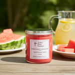 Load image into Gallery viewer, 2 wick hand poured Candle labeled 'Watermelon Lemonade' on a table with watermelon and lemonade in the background. Southern Charm Farmhouse.