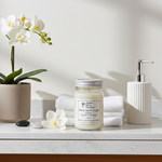 Load image into Gallery viewer, 16 oz Hand poured Mason Jar White Tea & Ginger Candle, towels, and a bottle on a marble surface with a white background. Southern Charm Farmhouse.