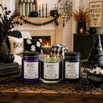 Load image into Gallery viewer, Three hand-poured scented candles from Southern Charm Farmhouse. are displayed on a rustic wooden table in a cozy, decorated living room setting.