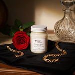 Load image into Gallery viewer, Luxury Baccarat Rouge candle in a 16 oz mason glass jar styled on a dark desk with a rose and decanter beside it. Southern Charm Farmhouse