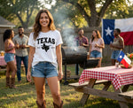 Load image into Gallery viewer, Woman wearing a 'Texas' t-shirt standing in a backyard with friends and a barbecue grill. Southern Charm Farmhouse.