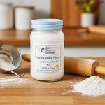 Load image into Gallery viewer, 16 oz mason Jar of Vanilla Maple Pecan hand poured candle with a label on a wooden surface with kitchen items. Southern Charm Farmhouse.