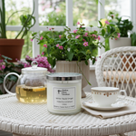 Load image into Gallery viewer, White Tea & Ginger 2 Wick hand poured Candle, teacup, and teapot on a table with plants in the background. Southern Charm Farmhouse.