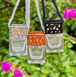 Load image into Gallery viewer, Three glass car perfume bottles with decorative tops hanging against a green foliage background. Southern Charm Farmhouse.