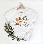 Load image into Gallery viewer, Hello Fall white T shirt hanging with a white background and leaves. Southern Charm Farmhouse.