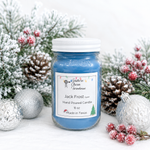 Load image into Gallery viewer, A blue hand-poured candle in a clear glass jar with a white lid and a white label reading 'Southern Charm Farmhouse' and 'Jack Frost. The candle is styled with snowy pine branches, pinecones, silver ornaments, and red berries on a white background.
