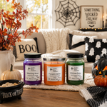 Load image into Gallery viewer, Two 16 oz mason jar hand poured candles labeled Witching Hour and Witches Brew. One 2 wick hand poured candle labeled Pumpkin Hollow sitting in a Halloween theme living room. Southern Charm Farmhouse
