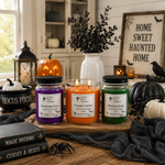 Load image into Gallery viewer, Three lit hand-poured candles in glass jars with black lids are displayed on a wooden tray in a Halloween-themed setting. The candles have purple, orange, and green wax, labeled 'Cultured Candles' with scents 'Witching Hour', 'Pumpkin Hollow', and 'Witches Brew'. Southern Charm Farmhouse
