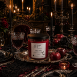 Load image into Gallery viewer, A red hand-poured candle labeled Bite Me in a glass jar with a black lid sits on an ornate silver tray, styled in a dark, gothic table setting with black candles, crystal glasses, red apples, and roses. Southern Charm Farmhouse.
