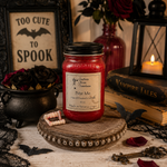 Load image into Gallery viewer, A red wax hand poured candle in a 16 oz mason  jar with a black lid sits on a decorative wooden tray in a styled Halloween scene. The jar label reads ' Bite Me ' . Southern Charm Farmhouse.
