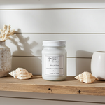 Load image into Gallery viewer, Black Sea Candle in a 16 oz Mason jar on a wooden surface with seashells and decorative pots. Southern Charm Farmhouse.
