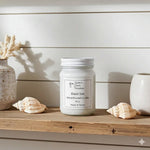 Load image into Gallery viewer, Black Sea Candle in a 16 oz Mason jar on a wooden surface with seashells and decorative pots. Southern Charm Farmhouse.
