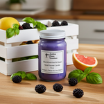 Load image into Gallery viewer, Purple hand poured candle labeled 'Blackberries &amp; Basil' on a wooden surface with blackberries, basil, and a crate in the background. Southern Charm Farmhouse.
