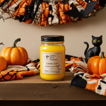 Load image into Gallery viewer, Hand poured Candle 16 oz mason jar labeled 'Candy Corn' on a Halloween-themed surface with pumpkins and a black cat. Candy Corn Candle | Sweet Halloween Candle | Southern Charm Farmhouse
