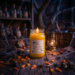 Load image into Gallery viewer, A lit hand poured candle in a 16 oz mason jar sits on a rustic wooden surface surrounded by Halloween decor, including candy corn, spiderwebs, small skulls, and a lantern. The label reads 'Candy Corn' . Southern Charm Farmhouse
