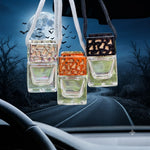 Load image into Gallery viewer, Three hanging car air fresheners with rectangular glass bottles and decorative caps, shown in front of a car windshield with a spooky road scene outside. Southern Charm Farmhouse
