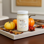 Load image into Gallery viewer, 16 oz mason Jar of Caramel Cappuccino Brulee hand poured candle with pumpkins and leaves on a wooden surface.  Southern Charm Farmhouse.

