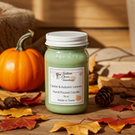 Load image into Gallery viewer, 16 oz Mason Jar Green hand poured candle in a jar named Cedar &amp; Autumn Leaves on a wooden surface with pumpkins and leaves.  Southern Charm Farmhouse.
