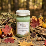 Load image into Gallery viewer, Green 16 oz mason jar hand poured candle labeled 'Cedar &amp; Autumn Leaves' with autumn-themed decorations on a wooden surface.  Southern Charm Farmhouse.
