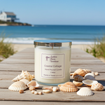 Load image into Gallery viewer, 2 wick hand poured Candle labeled 'Coastal Cottage' on a wooden boardwalk with seashells and ocean view. Southern Charm Farmhouse.
