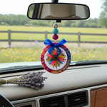 Load image into Gallery viewer, Decorative car freshie hanging with colorful design on a car dashboard with a blurred outdoor background. Southern Charm Farmhouse.
