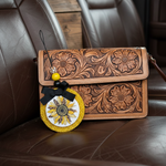 Load image into Gallery viewer, Country Sunflower car freshie leaning on a Brown leather handbag with floral  leather patterns on a brown leather surface. Southern Charm Farmhouse.
